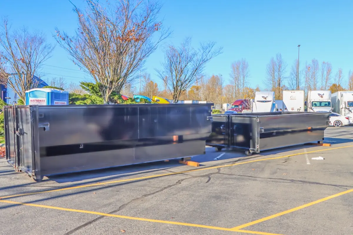 Professional dumpster rental service with roll-off container on residential driveway in West Springfield